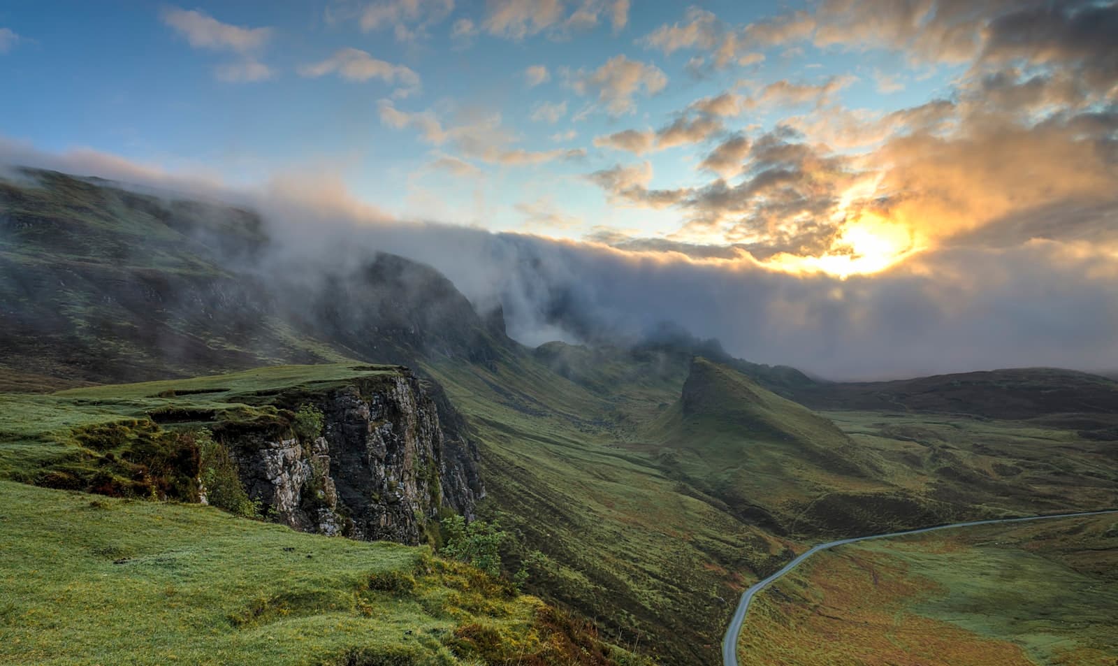 Dawn breaking over quiet green hills
